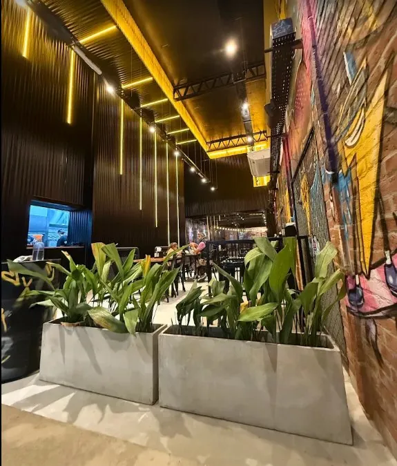 Interior del local de TMT en Mario Bravo, con mural y plantas